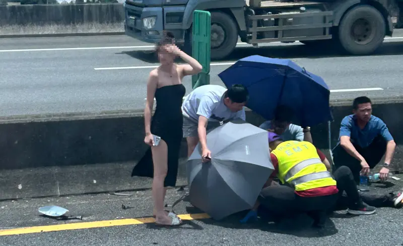 ▲國道2號今天傳出一起翻覆意外，其中一名身穿開高衩洋裝的女子在一旁協助指揮交通，意外引發網友熱議。（圖／翻攝畫面）