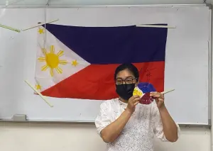 ▲羅戴娜講師介紹菲律賓文化，並和大家一起製作國旗顏色的法式花邊杯墊。（圖／移民署提供）