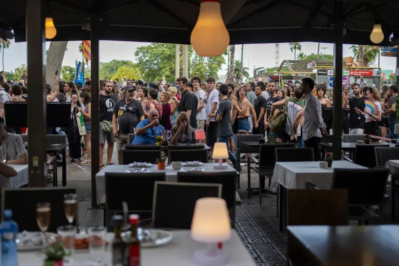 ▲當地居民上街抗議,許多遊客則仍待在露天餐廳用餐。(圖/美聯社/達志影像)