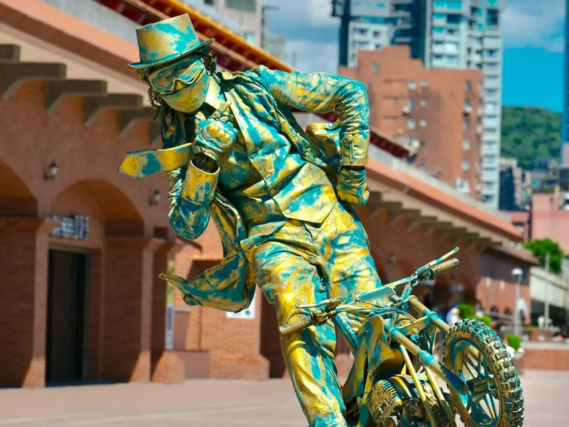 ▲藝術家「蚊子」頂著烈日在捷運淡水站外表演「行動雕像」，被讚超敬業，不少粉絲擔心他全身包緊緊可能會中暑。（圖／翻攝滬尾小鎮臉書）