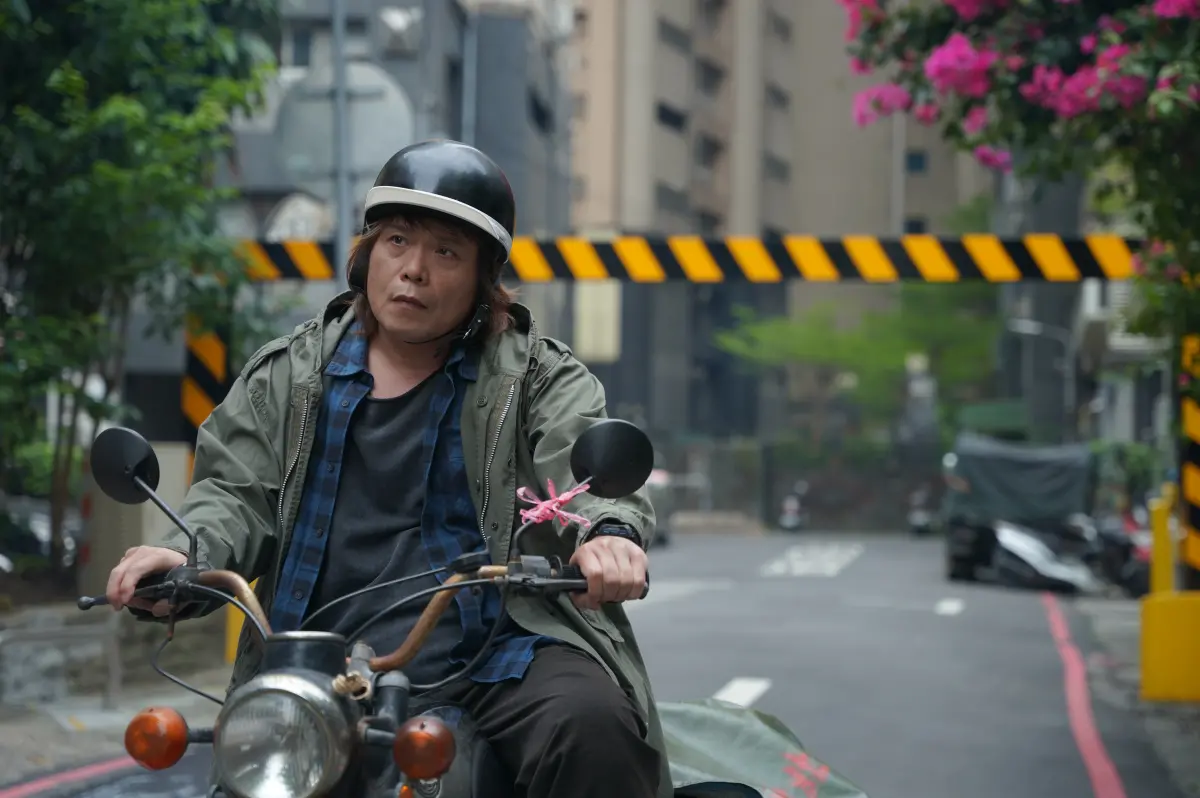 ▲「金曲歌王」伍佰參演《愛情城事》，化身派報員騎車穿梭巷弄。（圖／華映）
