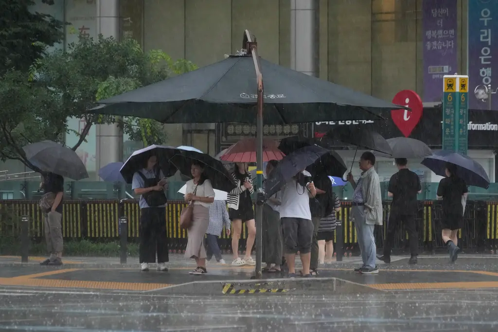 ▲韓國首爾、京畿道北部今（17）日上午降下百年一遇暴雨，多地時雨量超過100毫米，而京畿道北部的坡州市板門店時雨量更達到驚人的358.5毫米，許多民眾在上班途中被困在淹水路段，地鐵和電車也因豪雨停駛。（圖／美聯社／達志影像）