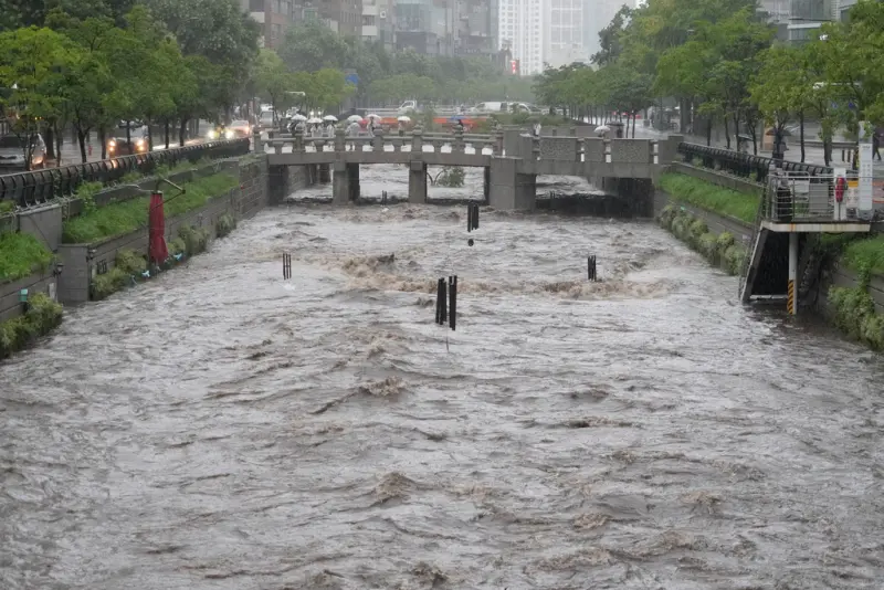 ▲韓國極限暴雨導致市區道路淹水交通中斷,部分道路甚至淹水高度至成人膝蓋,郊區河川暴漲,傳出諸多災情。(圖/美聯社/達志影像)