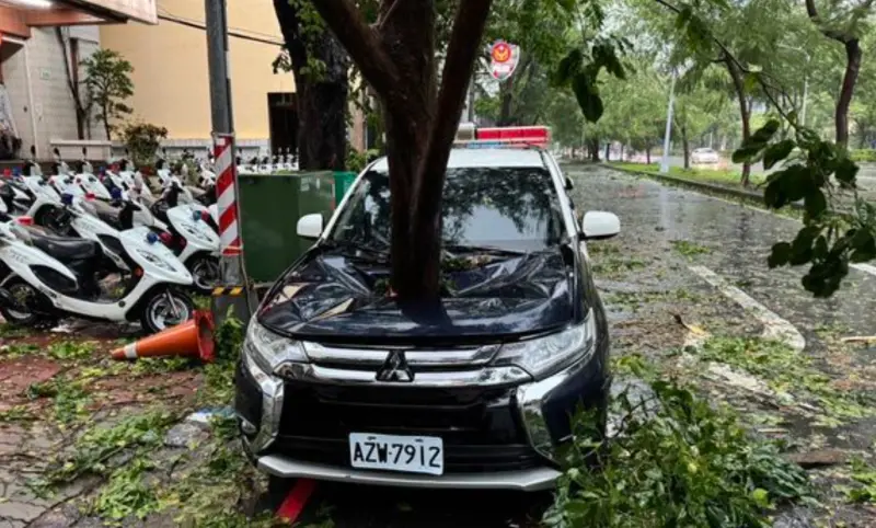 ▲強颱凱米暴風襲台，高雄鼓山分局龍華派出所，一台警車遭路樹砸中，整個車頭凹陷，所幸未造成人員傷亡。（圖／翻攝畫面）