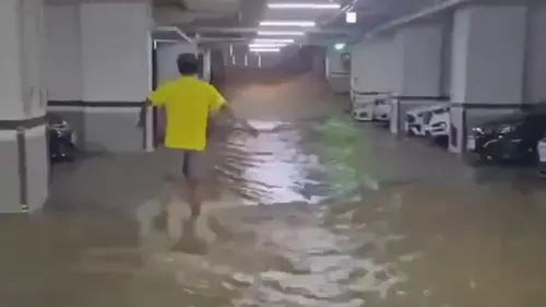 ▲凱米颱風造成高雄左營桃子路淹水，居民為防止水淹停車場，齊力關閉水閘門。（圖／翻攝畫面）