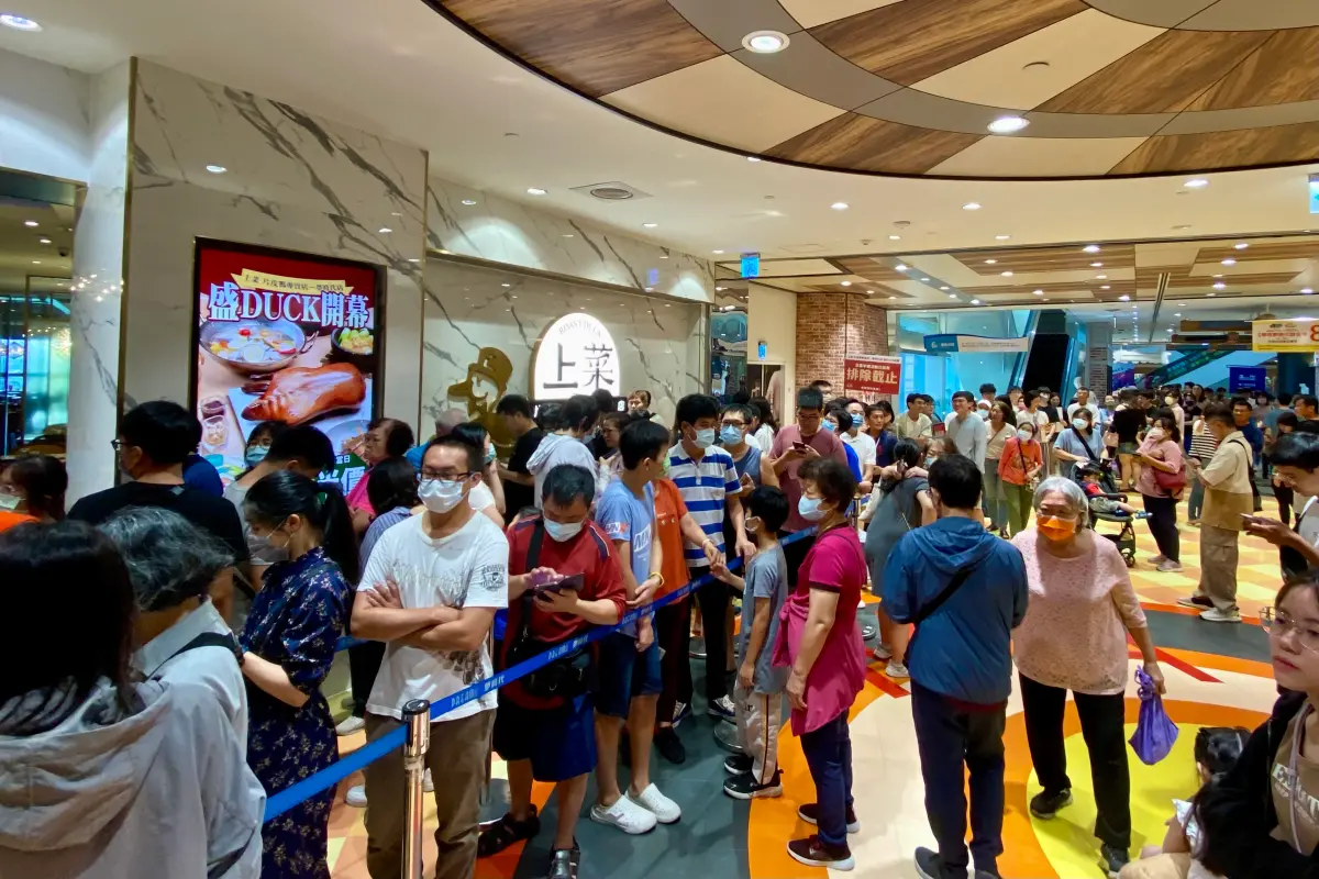 ▲漢來美食旗下片皮鴨專賣店「上菜 」，進駐高雄夢時代百貨，今（26）日開幕首日，祭出前50組顧客內用和菜，將可享𝟱折優惠。營業時間還未到，就已擠滿人潮。（圖／記者葉盛耀攝）