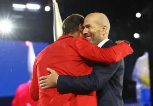 Nadal(左)將聖火傳給法國足球傳奇Zinedine Zidane(席丹),之後兩人英雄惜英雄相擁。(圖/美聯社/達志影像) ▲Nadal(左)將聖火傳給法國足球傳奇Zinedine Zidane(席丹),之後兩人英雄惜英雄相擁。(圖/美聯社/達志影像)