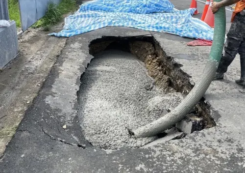 ▲苗栗縣後龍鎮、維真國中對面一處大樓建案，疑似因凱米颱風大雨，加上工地重車輾壓，路面竟出現一個巨大坑洞。（圖／翻攝畫面）