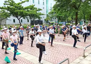 ▲產業園區管理局高屏分局舉辦臨廣科技產業園區百人健走活動，由高屏分局分局長游淑惠(前左1)帶領參與從業人員熱身。(圖／產業園區管理局高屏分局提供)