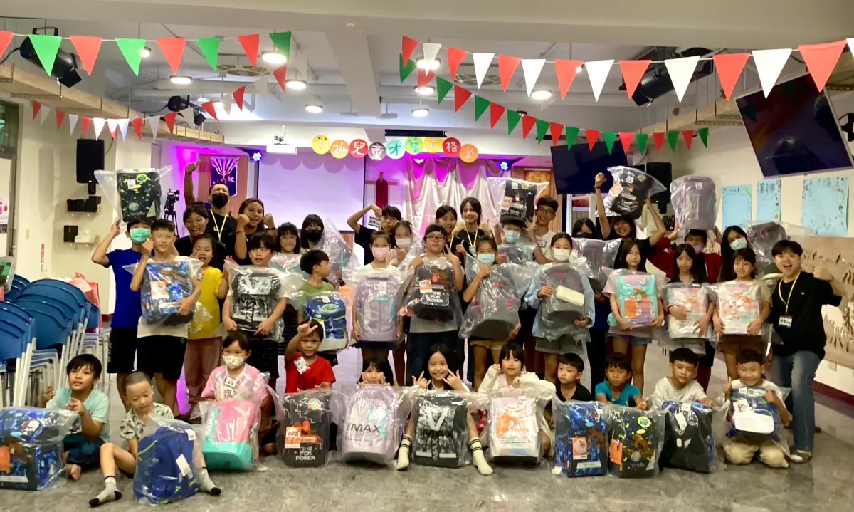 ▲一粒麥子基金會課輔班學童開心展示Tiger Family捐贈護脊書包。(圖／業者提供）