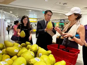 ▲黃偉哲親自下場向新加坡消費者介紹如何挑選文旦。（圖／南市府提供）