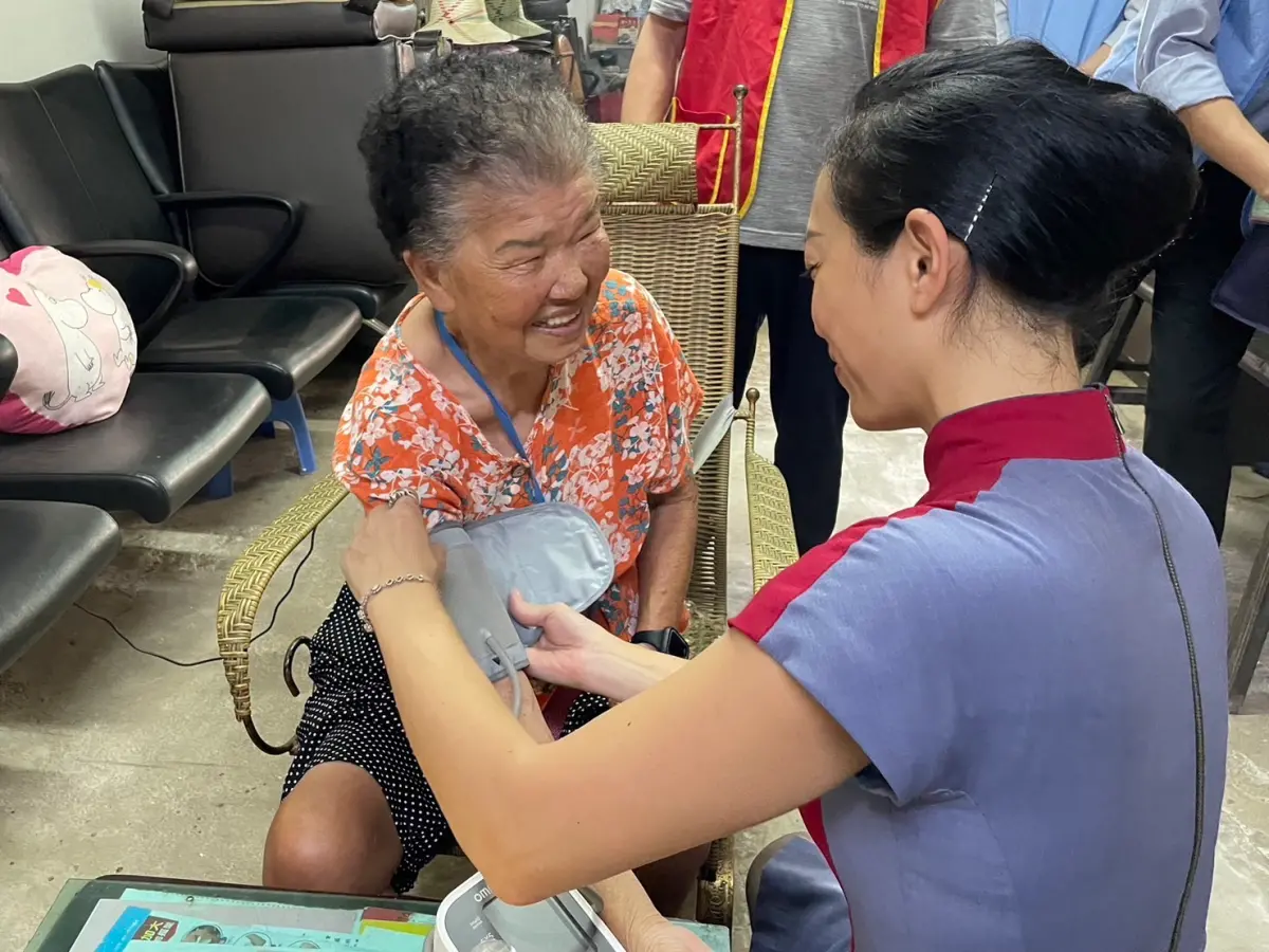 ▲華航志工協助長者量血壓。（圖／華航提供）
