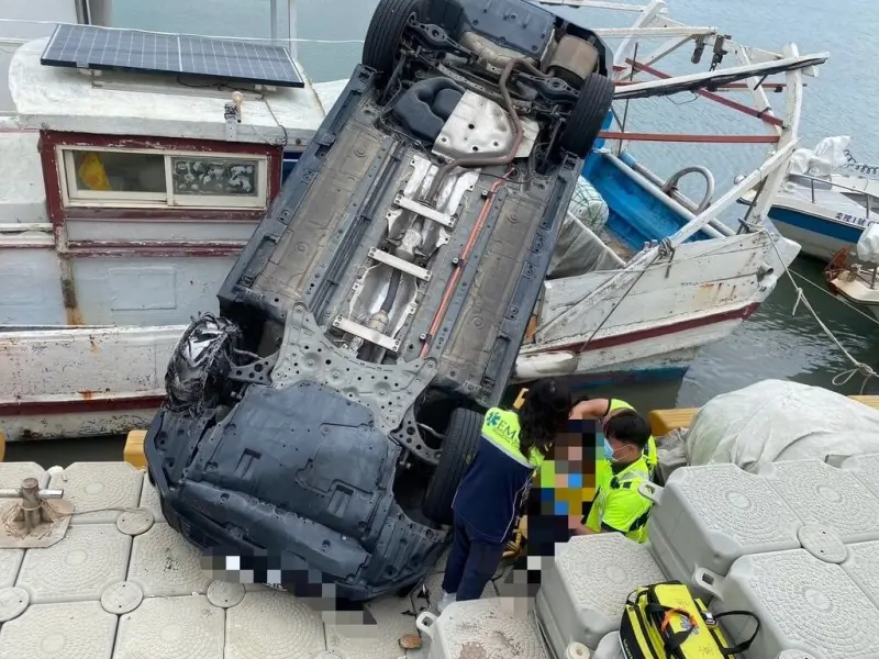 ▲新竹市南寮漁港今天下午發生1輛自小客車不明原因衝出碼頭，掉落港邊浮動碼頭及1艘停靠港邊的漁船上，所幸未墜入海中，事故原因待警方調查釐清。（圖／翻攝畫面）