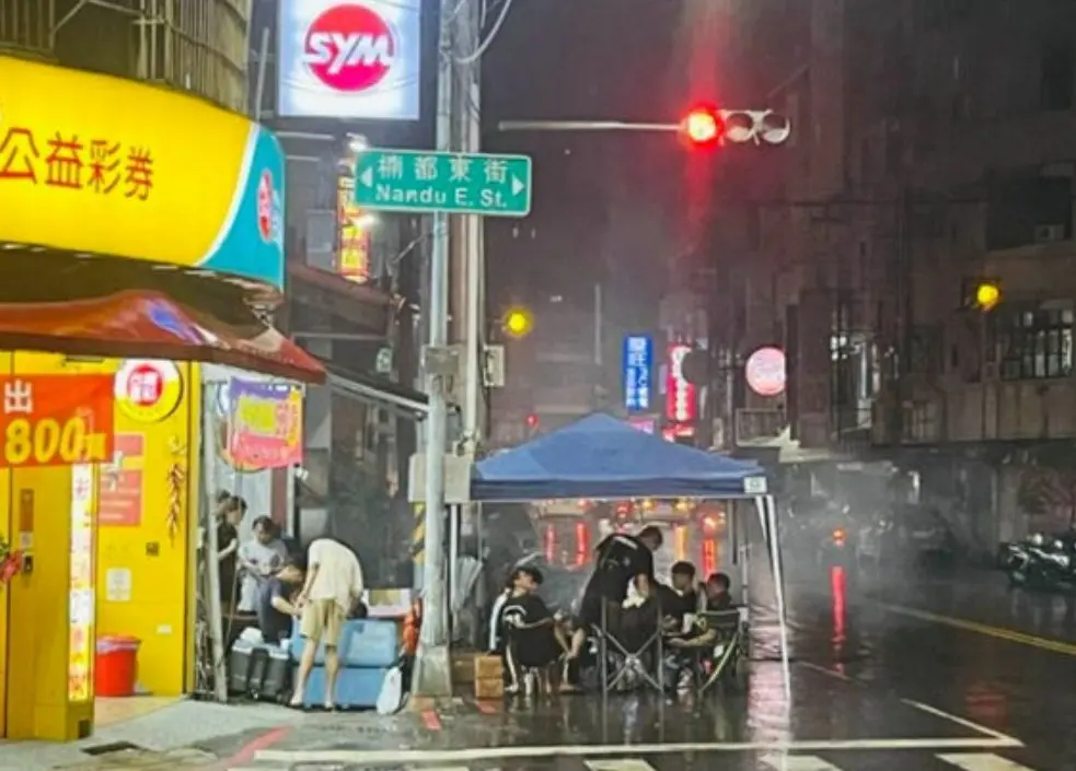 ▲14日晚間，高雄楠梓區朝陽路、楠都東路口，有群年輕人竟在紅綠燈號下方，直接搭起帳棚烤肉，警方獲報趕抵現場，直接開出1200到2400元罰單。（圖／翻攝畫面）