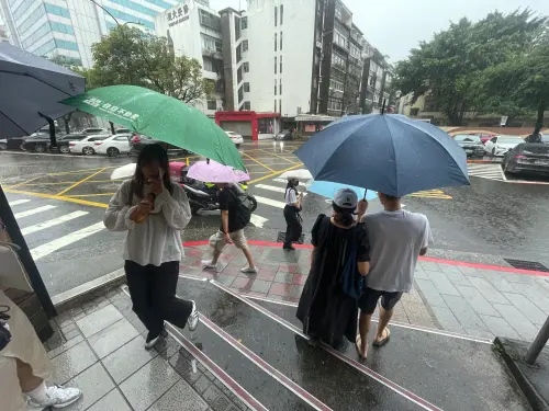 ▲ 超大豪雨侵襲雙北，民眾紛紛在外撐傘或找地方躲雨。（圖／吳政紘攝）