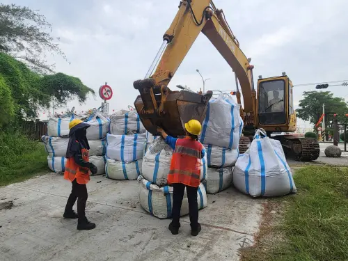 ▲南市府今早即在濱南路的防風林缺口架設太空包，以防止海沙吹到路面上。（圖／南市府提供）