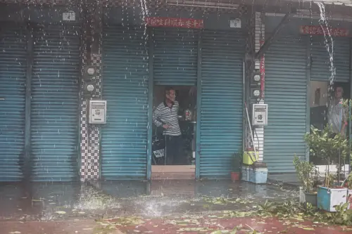 ▲高雄今（3）狂風暴雨，阿伯從自家探頭查看雨勢，盼望風雨早點停歇。（圖／記者葉政勳攝）