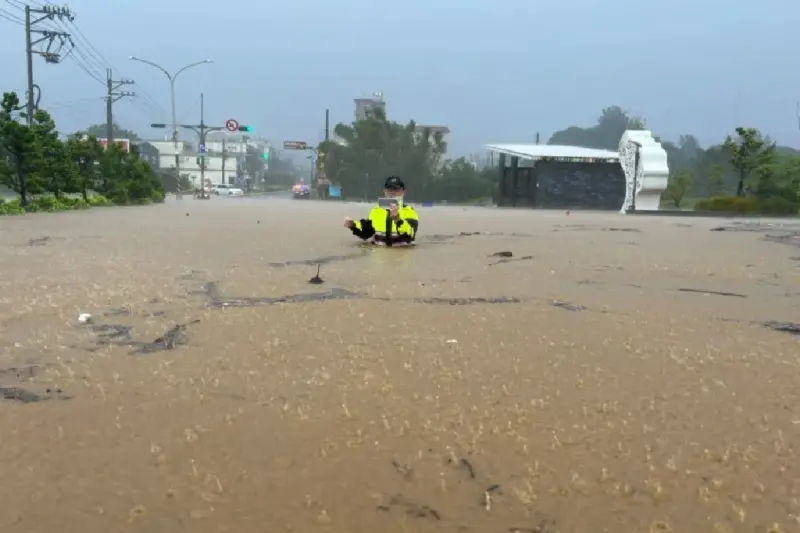 ▲山陀兒颱風帶來暴雨侵襲北海岸，4日下午 ，台2線44號橋下溪水暴漲，金山分局一名員警前往值勤，整個人泡在水中，水高度淹到胸口處。（圖／翻攝畫面）