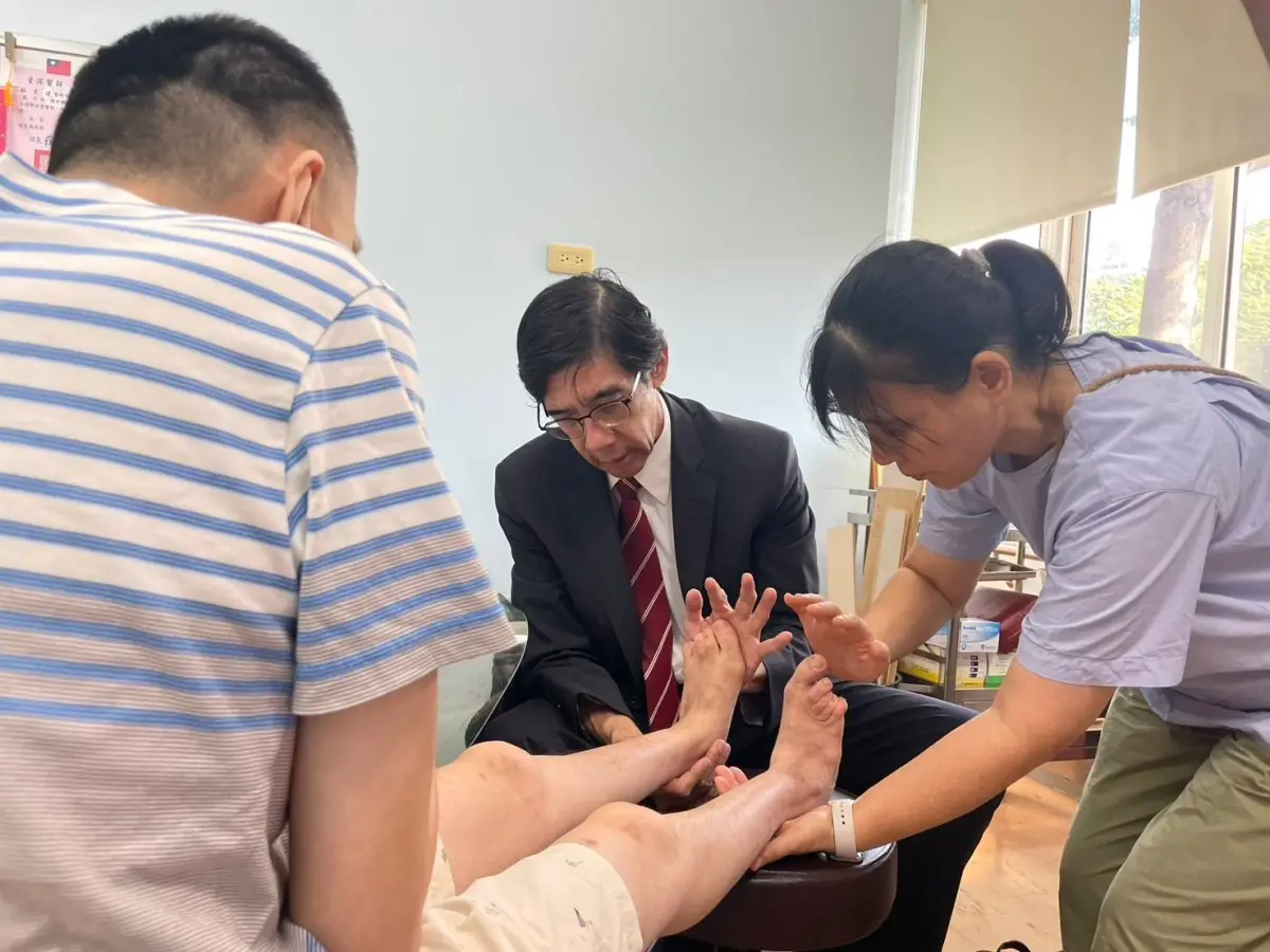 ▲李光申醫師教導患者媽媽如何幫服務對象進行腳拉筋，舒緩腳後跟疼痛。（圖/瑪利亞基金會提供）