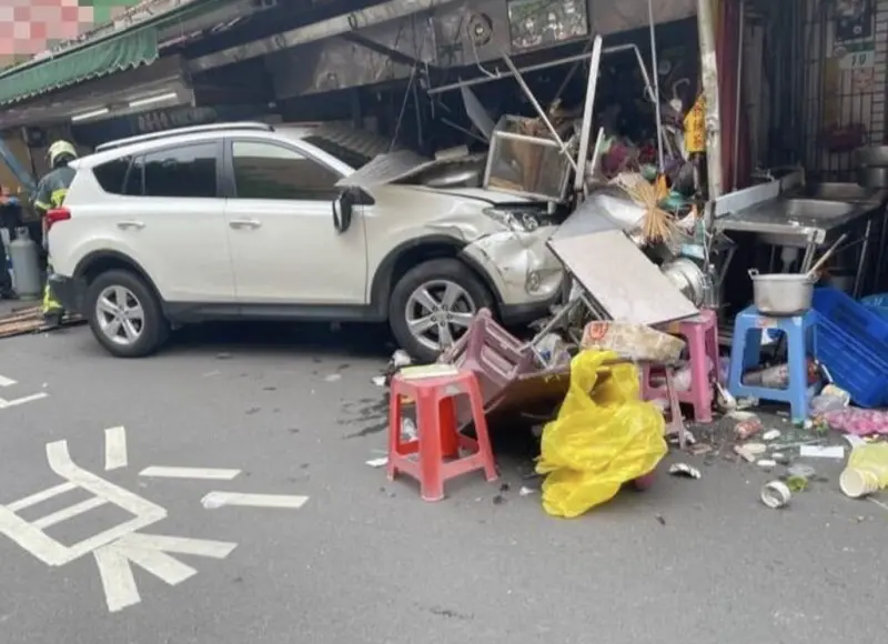 ▲北市一名林女駕車失控擦撞轎車，再撞進霞海城隍廟旁的攤位，導致一名葉姓老闆娘受輕傷。（圖／翻攝畫面）