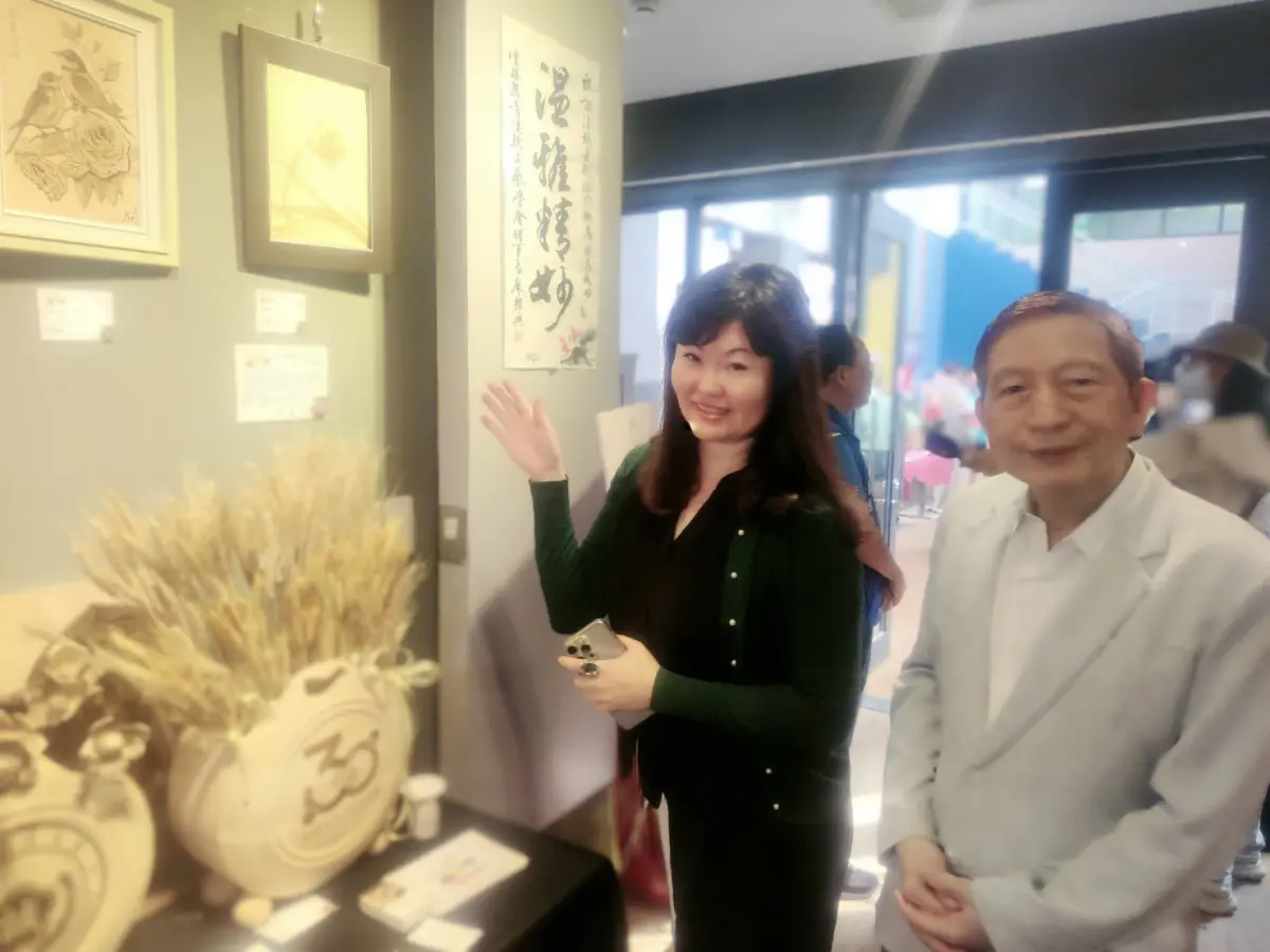 ▲理事長廖淑芬（左）闡述展出作品以及烙畫藝術魅力，吸引許多愛畫民眾觀賞。（圖／協會提供）