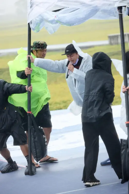 因為現場颳起狂風,許富凱邊扶著雨棚邊唱歌。(圖/許富凱臉書) ▲因為現場颳起狂風,許富凱邊扶著雨棚邊唱歌。(圖/許富凱臉書)