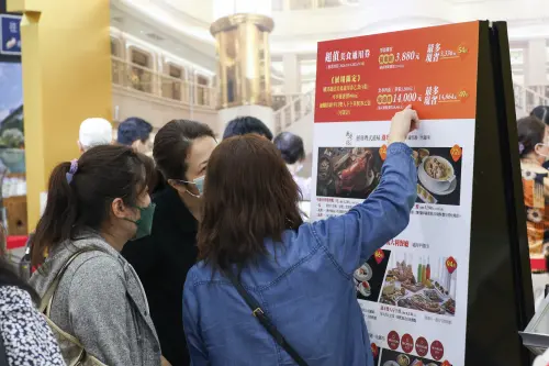 ▲民眾認真研究各家飯店的住宿券，與餐券之優惠。（圖／記者陳明安攝）