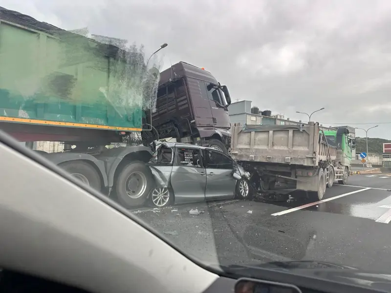 ▲22日上午，台61線發生重大車禍，一台砂石車疑追撞前方車輛，小客車被擠壓在中間，車體凹陷扭曲變形，駕駛傷重不治。（圖／翻攝畫面）