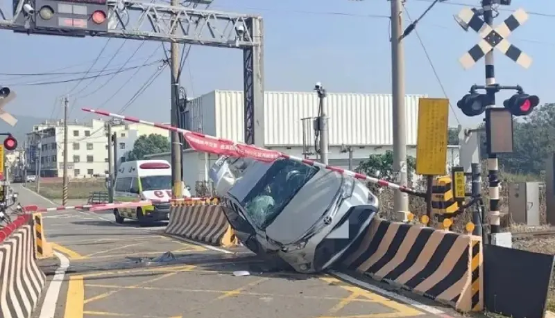 ▲3日上午，台中張姓女子駕駛汽車，疑恍神不慎自撞平交道，整台車斜掛在紐澤西護欄，右側車身嚴重受損。（圖／翻攝畫面）