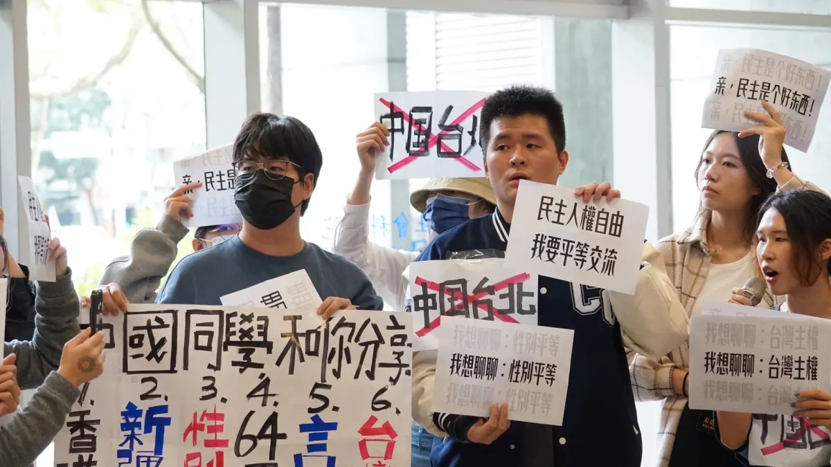 ▲此次的活動在政治上高度敏感，然該活動卻被高度保密，社科院學生在活動發生前，無法透過任何公開管道，尤其是社科院學生會方得知相關消息。圖為台大學生舉牌向陸生團抗議。（圖／經民聯提供）