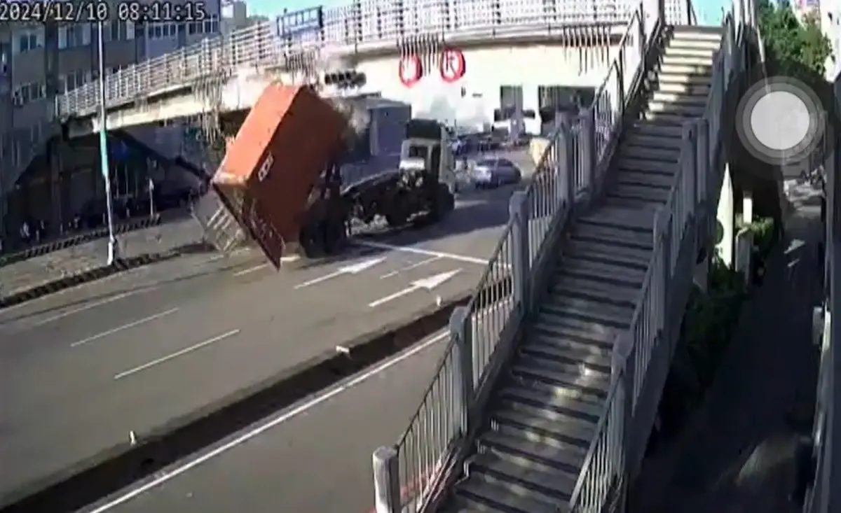 ▲10日上，台中沙鹿區台灣大道七段，一台貨櫃車因未將車斗降下，結果貨櫃撞上路橋後、直接脫離車身墜落地面。（圖／翻攝畫面）