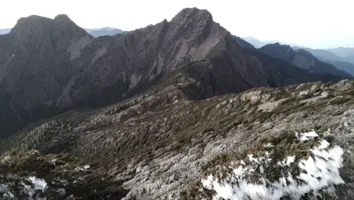 ▲玉山氣象站周圍出現「霜淞」現象，原本一片綠油油的大地，被染上幾塊鮮白。（圖／玉山氣象站提供）