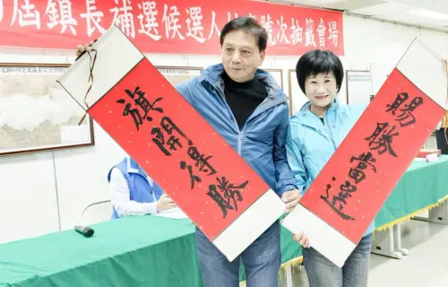南投草屯鎮長補選捉對廝殺 綠蔡銘軒1號、藍簡賜勝2號 ▲簡賜勝和妻子拿出「旗開得勝」、「賜勝當選」的紅色捲軸。(圖/蔡銘軒提供,2024.12.20)