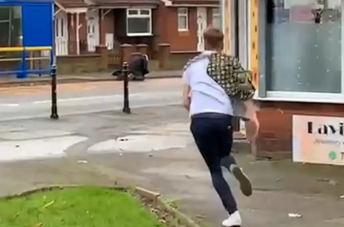 ▲英國1名叫做懷廷的男子，近日在理髮時目睹一樁襲警案發生，他顧不得頭髮還沒剪完，披著理髮巾就衝出去幫忙的畫面，讓他在網路上得到英雄的稱號。（圖／美聯社／達志影像）