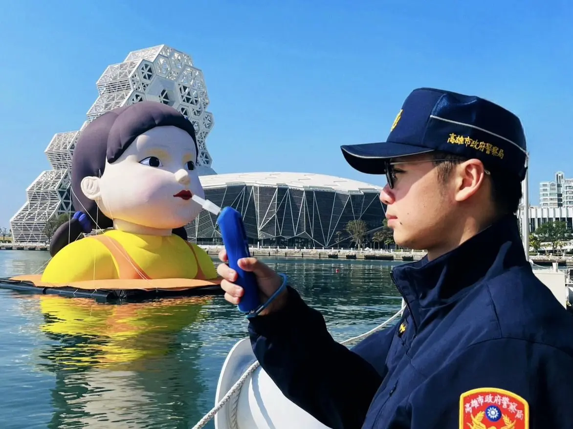 ▲Netflix《魷魚遊戲2》在高雄舉辦造勢活動，巨型英熙娃娃出現在高雄流行音樂中心前水面，鹽埕分局「借位」讓英熙被酒測，吸引4萬多人狂讚。（圖／取自鹽埕警.駁二驛站臉書）