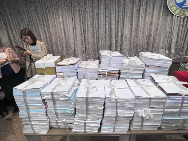 ▲台北地院下午公開抽籤柯文哲案的承審法官,由衛股法官許芳瑜中籤,隨該案移送的卷宗多達148宗,擺滿整桌,非常驚人。(圖/記者徐敏娟攝)