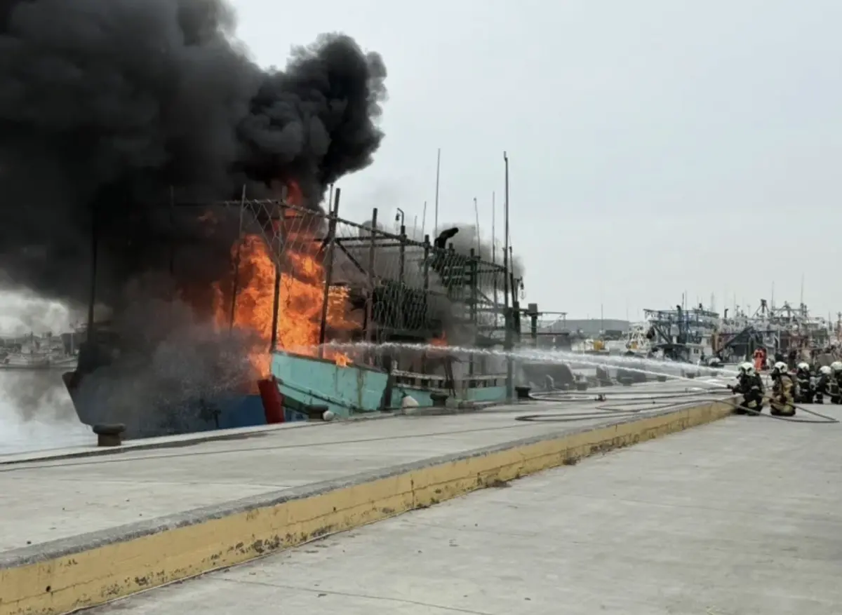 ▲一艘新北野柳籍漁船今（27）日停泊於興達漁港港區，今早11點突然冒出濃煙及火光，船體陷入火海，陣陣黑煙冒在海面上。（圖／海巡署提供）