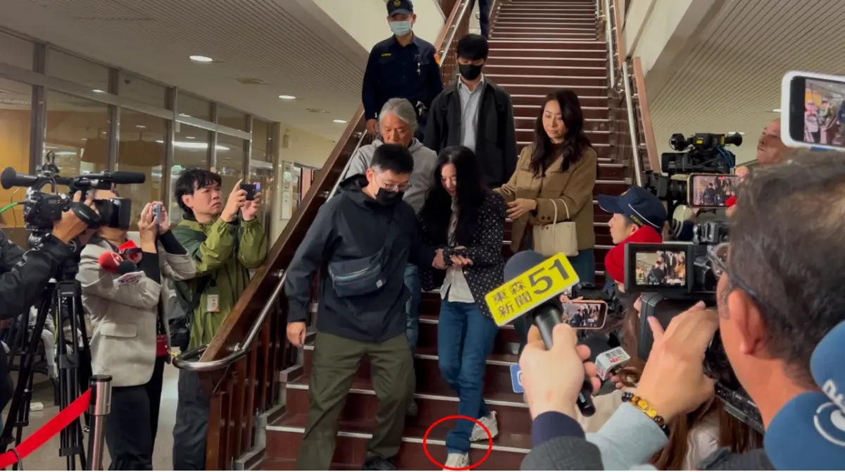 ▲應曉薇面露微笑，在親友攙扶下離開台北地院，雖然她穿著牛仔長褲，但在左腳處，還是能夠看得出來電子腳鐐被褲管遮住，明顯鼓起一大包。（圖／記者徐敏娟攝）