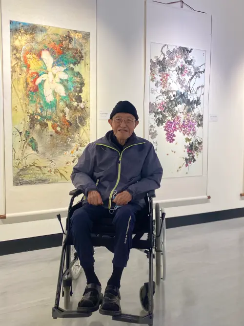 ▲90多歲的陳老先生,在聽聞在高雄文化中心有復興崗藝術學系校友聯合美展,他坐著輪椅也要過來看聯展。(圖/郭凱杰攝) ▲90多歲的陳老先生,在聽聞在高雄文化中心有復興崗藝術學系校友聯合美展,他坐著輪椅也要過來看聯展。(圖/郭凱杰攝)