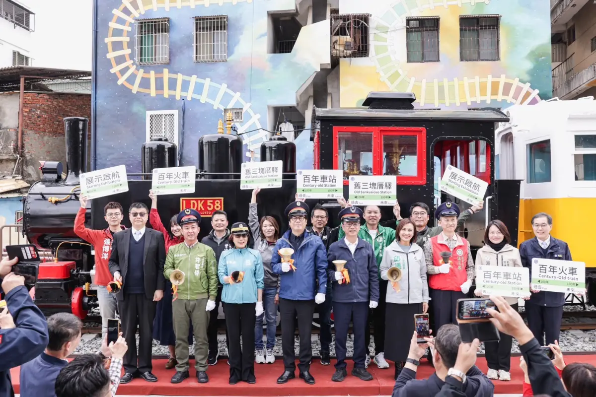 ▲陳其邁與臺鐵公司董事長杜微及多位立委與市議員等人，戴上帽子化身站長，揮動搖鈴正式宣告三塊厝驛「百年車站 百年火車」啟航。(圖／高市府提供)