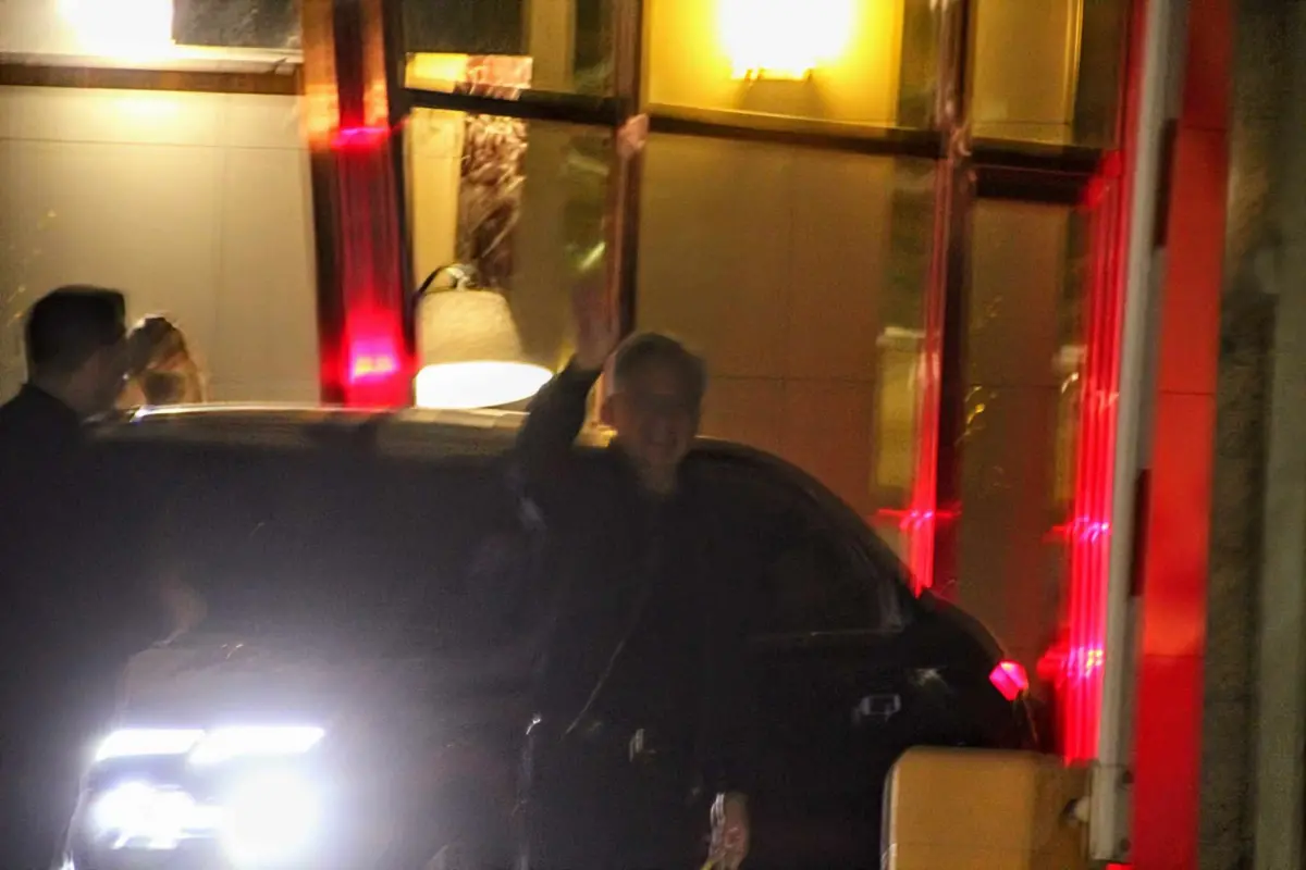 ▲黃仁勳用餐約2小時後，下樓準備搭車離開，期間不斷對記者喊話說「早點回家」。（圖／記者鍾泓良攝影）