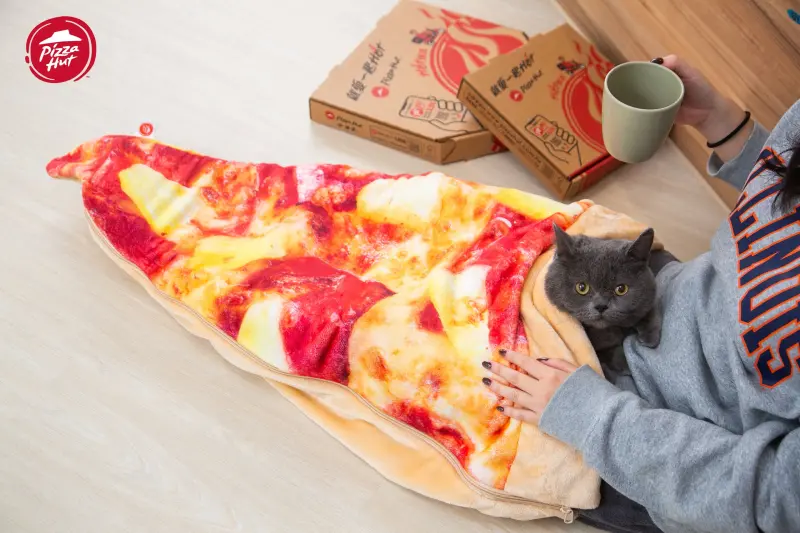 ▲必勝客過年又在玩食物！「超巨大夏威夷披薩睡袋」春節廢在家追劇好實用，變身家中小孩、貓狗萌寵專屬被窩，加價399元全台開搶。上友的短尾矮袋鼠「DINOTAENG呆萌町戳戳樂禮盒」也好玩又好吃。（圖／必勝客提供）