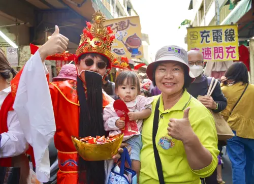 身穿金紅傳統長袍的財神爺,在喜氣洋洋的音樂陪伴下出現在市場圓環 ▲身穿金紅傳統長袍的財神爺,在喜氣洋洋的音樂陪伴下出現在市場圓環。(圖/屏東縣府提供)