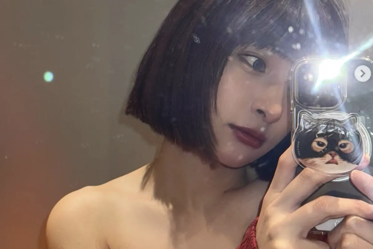 ▲峮峮穿著平口紅色上衣，頭上還夾著「發」字的髮夾，紅紅火火的穿搭，被粉絲說打牌應該會自摸。（圖／翻攝自峮峮IG）