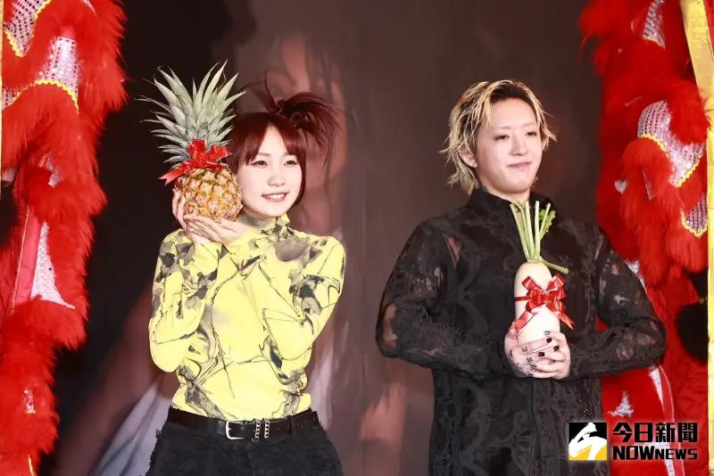 ▲YOASOBI成員Ayase（右）、ikura（幾田莉拉）舉辦記者會，高舉鳳梨、菜頭「預告唱進大巨蛋」。（圖／記者葉政勳攝）