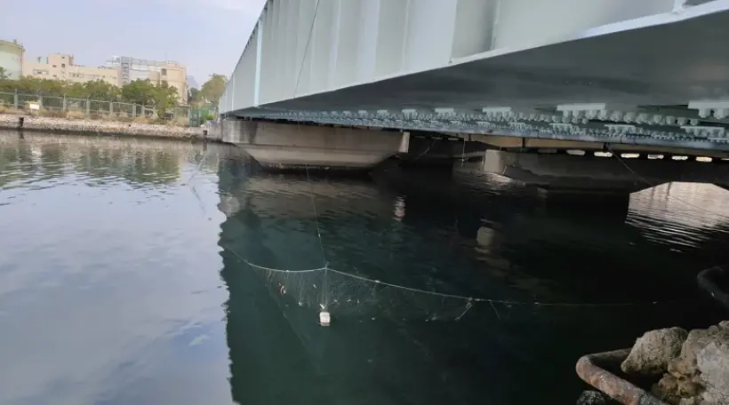 ▲警方為避免屍塊隨著海流，飄出高雄港外海後，將更難尋找，因此昨下午在第五船渠成功橋下，利用漁網圍起攔截網，不放過任何可疑「人體組織」，可以將其全部攔截。（圖／翻攝畫面）