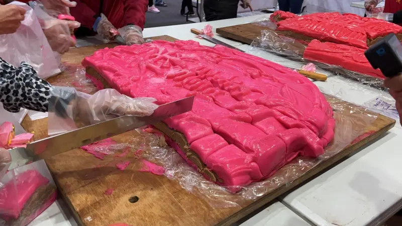 ▲新丁粄與紅龜粿最大的不同點在內餡，新丁粄只有花豆餡，圖為超大新丁粄分切過程。（圖／台中市政府提供，2025.02.11）