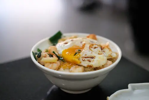 吃蝦仁飯,老饕們都不忘加上一顆煎雞蛋,配上未全熟蛋黃相當誘人。(圖/記者葉盛耀攝) ▲吃蝦仁飯,老饕們都不忘加上一顆煎雞蛋,配上未全熟蛋黃相當誘人。(圖/記者葉盛耀攝)