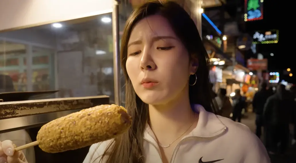 ▲南珉貞到墾丁大街買烤玉米實測物價，發現一根只要只要68元時，她覺得非常划算還當場嚇到，懷疑網路上的負評是造謠。（圖／남민정 南珉貞YouTube）