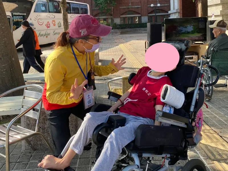 ▲倡導關懷人陪伴小素阿嬤在機構裡活動，並常以活潑的肢體動作與小素阿嬤互動。（圖／屏東縣府提供）